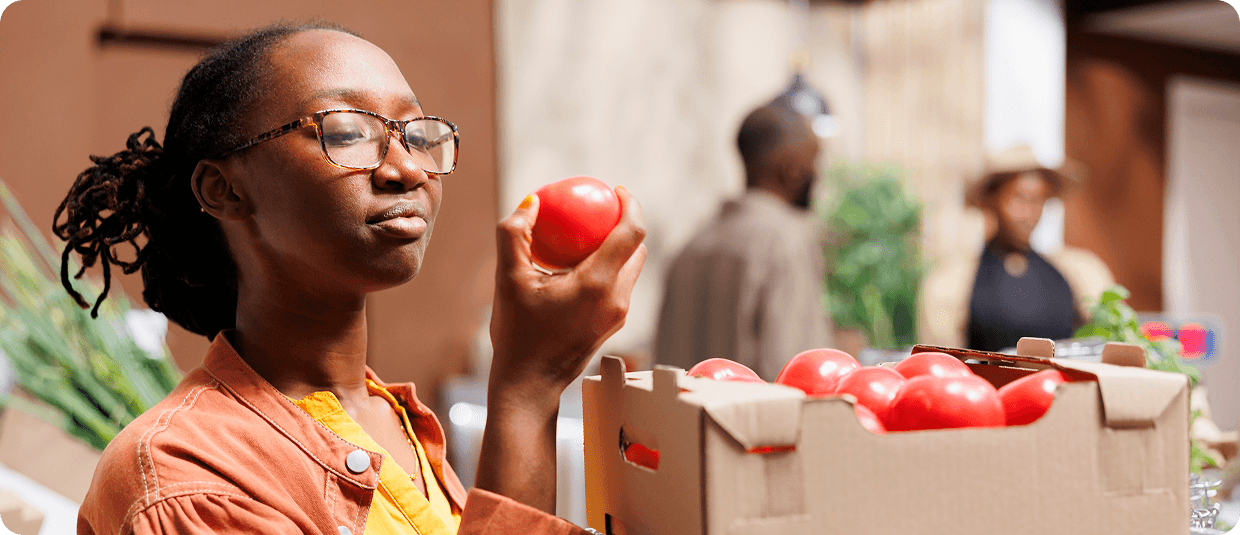 Woman shopping for fresh tomatoes at a local market